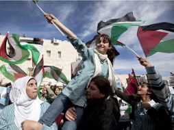 Mujeres palestinas bailan y ondean banderas durante la concentración en apoyo a la propuesta de Abás ante la ONU. EFE  /