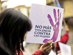 Una mujer camina junto a un cartel contra la violencia de género hoy en Pamplona. EFE  /