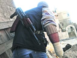 Tensión. Un rebelde sirio se oculta de las fuerzas del presidente Bachar al Assad, cerca de Aleppo. REUTERS  /