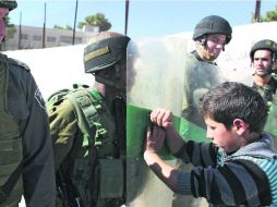 Policías observan a un niño que no ceja en su empeño de transgredir la ley, en una manifestación de apoyo al presidente Morsi. REUTERS  /
