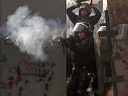 Policía federl lanzando gas lacrimógeno. López Obrador aseguró que no había razón para agredir a los manifestantes. AP  /