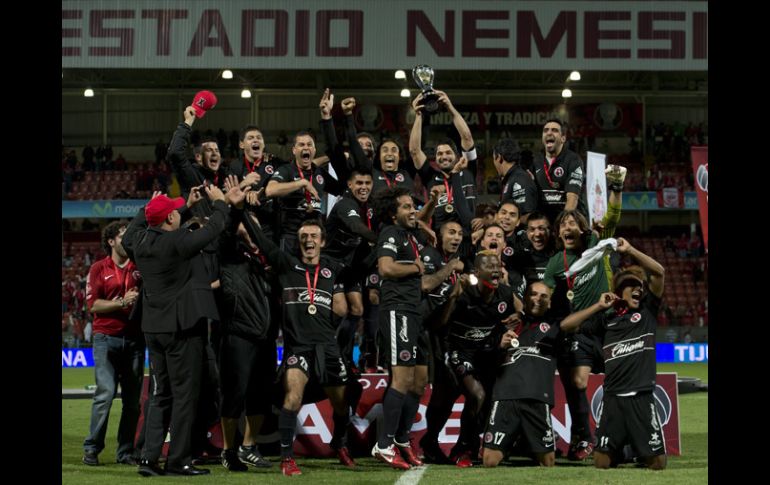 Los jugadores de Xolos de Tijuana levantan el trofeo que los hace campeones del Apertura 2012. MEXSPORT  /