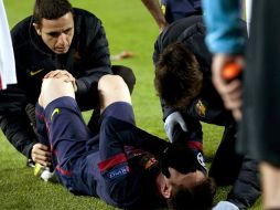 Lionel Messi recibe la atención de los médicos del Barcelona luego de su lesión. EFE  /