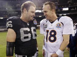 El mariscal de campo de los Broncos, Peyton Manning (derecha), habla con Cooper Carlisle, de los Raiders, al finalizar el partido. AP  /