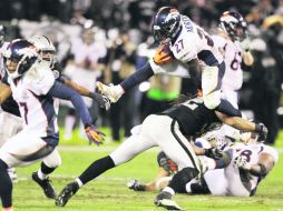 De mucha ayuda. Knowshon Moreno salta para eludir la tacleada de Philip Wheeler, durante el juego en la casa de los Raiders. AP  /