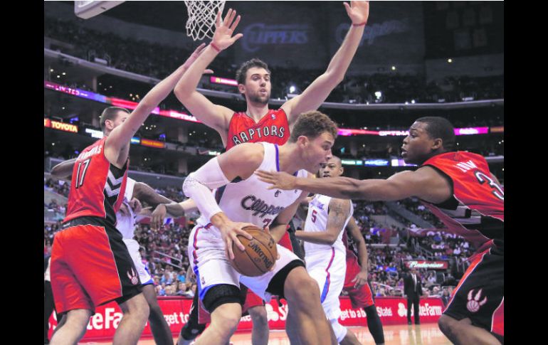 Imparable. Blake Griffin (de blanco) captura un rebote ante la marca de tres oponentes. AP  /
