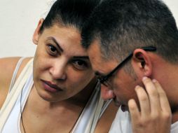 Alatorre habla con uno de sus compañeros durante el juicio en Managua. AFP  /