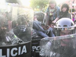 Detenciones. Policías de Guadalajara detienen a jóvenes manifestantes a las afueras de la Expo Guadalajara, el pasado 1 de diciembre.  /