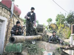Bien armados. Miembros del Ejército Libre de Siria ''patrullan'' en un tanque las calles de Aleppo. AP  /