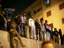 Seguidores de la oposición egipcia permanecen sobre un muro instalado para impedirles el acceso durante una protesta. XINHUA  /