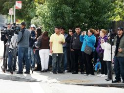 Varios seguidores y representantes de los medios de prensa esperan frente a la puerta del cementerio All Souls. EFE  /