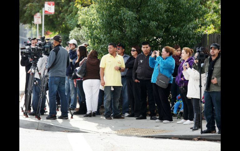 Varios seguidores y representantes de los medios de prensa esperan frente a la puerta del cementerio All Souls. EFE  /
