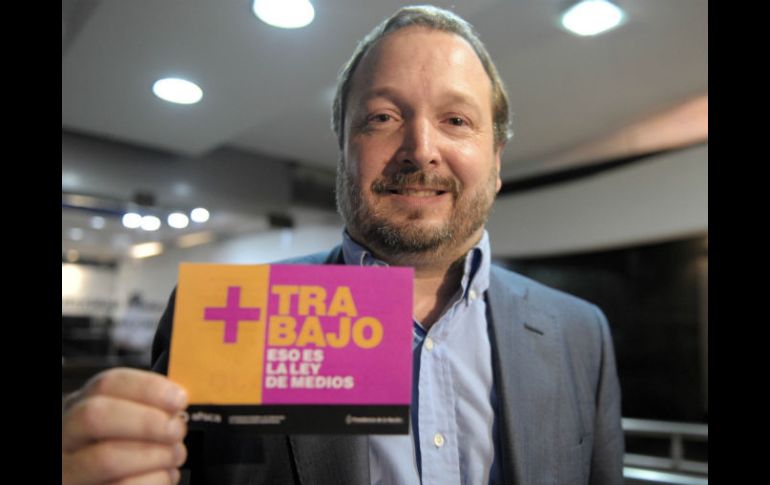 Funcionario muestra un panfleto con una leyenda a favor de Ley de Medios. XINHUA  /