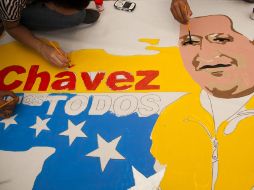 Simpatizantes de Chávez pintan una manta con la imagen del mandatario, en Caracas. AP  /