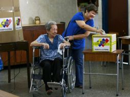 Una anciana es ayudada para poder votar durante las elecciones regionales en Venezuela. REUTERS  /