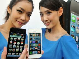 Dos modelos muestran al iPhone 5 durante el lanzamiento del producto en una tienda en Taipei. ARCHIVO  /