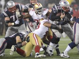 El quarterback de los Patriotas, Tom Brady es derribado por Will Tukuafu de los 49 de San Franciso EFE  /