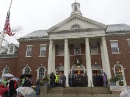 El gobernador de Connecticut, Dannel Malloy (c), escucha los 26 repiques de campana, en recuerdo a las víctimas de los tiroteos. EFE  /