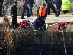 Rescatistas drenan el agua del estanque en que cayó el minibús en Jiangxi. XINHUA  /