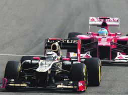 Se hace la lucha. Kimi Raikkonen conduce su auto, soportando los embates de Fernando Alonso. AFP  /