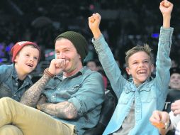 Disfruta. David Beckham (centro) observa un partido de la NBA con sus hijos Romeo (izquierda) y Cruz. AP  /