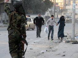 Habitantes se cubren en una zona de Alepo. Moscú se prepararía para desalojar a miles de rusos de Siria si es necesario. REUTERS  /