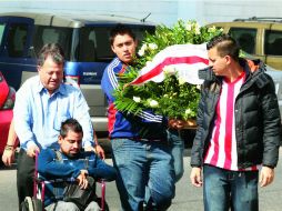 Respetos. Seguidores del equipo Guadalajara llegan al velorio con una corona fúnebre.  /
