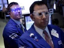 Trabajadores en la Bolsa de Nueva York usan lentes alusivos al nuevo año. AP  /