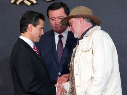 Peña Nieto y Sicilia (d), acompañados de Osorio Chong, se saludan en el marco de la Publicación de la Ley General de Víctimas. SUN /