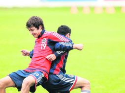 Buen ánimo. ''Cubo'' Torres realiza ejercicios de estiramiento con uno de sus compañeros al finalizar la práctica en Verde Valle. EL INFORMADOR /