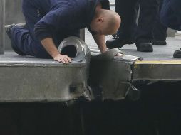 Un funcionario revisa el daño causado al muelle tras el choque. REUTERS /