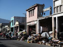 Personas caminan cerca de las ruinas de los locales comerciales de la avenida Desallines, en la capital haitiana. EFE /