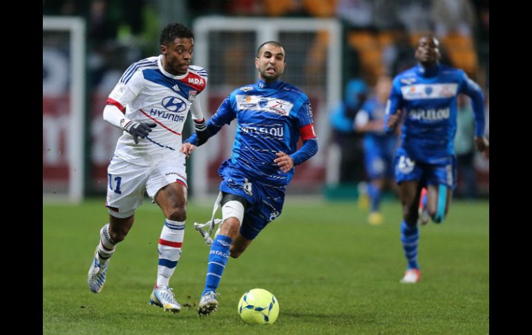 Mounir Obbadi del Troyes (i), corre frente al mediocampista del Lyon Bastos. AFP /