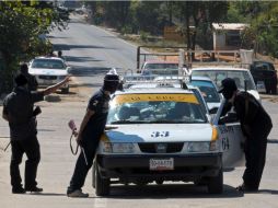 Civiles revisan automóviles en las carreteras, en Guerrero. AP /