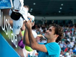 Roger Federer firma autógrafos tras finalizar el partido. XINHUA /