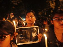Manifestantes sujetan pancartas y velas para protestar por la brutal violación en grupo de una estudiante. EFE /