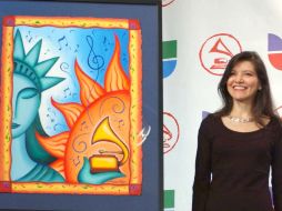 La artista mexicana, Andrea Arroyo, junto al poster que diseñó como emblema de una edición de los Grammys Latinos. ARCHIVO /