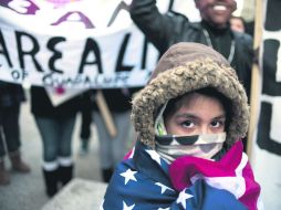 Marcha pacífica. Un niño arropado con la bandera estadounidense marcha con el contingente. EFE /