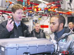 Lewis Hamilton escucha con atención la explicación acerca de un motor Mercedes, durante su visita a la planta en Stuttgart. EFE /