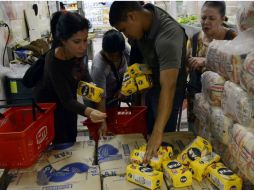 En algunos supermercados y panaderías restringen la cantidad de  productos básicos que puede comprar cada persona. AFP /