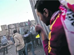 Revuelta popular. Opositores a Mohamed Mursi tratan de tirar un muro cercano a la Plaza Tahrir de El Cairo. XINHUA /
