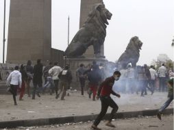Manifestantes en contra de Mursi corren del gas lacrimógeno arrojado por la polícia antimotines.. REUTERS /