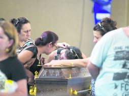 Familiares de las víctimas lloran frente al ataúd en el Centro Deportivo Municipal de Santa María, donde fueron llevados los cuerpos. XINHUA /