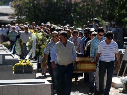 Familiares y amigos de los hermanos Pedro y Marcelo Salla, víctimas del incendio, cargan sus féretros. EFE /