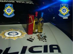 Fotografía que muestra los licores y armas aseguradas por las autoridades. ESPECIAL /