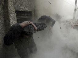 Dos hombres corren hacia el lado contrario del ataque. REUTERS /