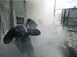 Bajo fuego. Insurgentes del Ejército sirio Libre corren para cubrirse del impacto de mortero, en Ain Tarma, Damasco. REUTERS /