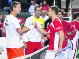 Tomas Berdych (de blanco) y el suizo Marco Chiudinelli (de rojo) estrechan su mano ante la mirada de Tomas Rosol y Stanislas Wawrinka. AFP /