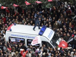 Manifestantes tunecinos rodean la ambulancia donde se encuentra el cadáver del líder opositor Chukri Belaid. EFE /