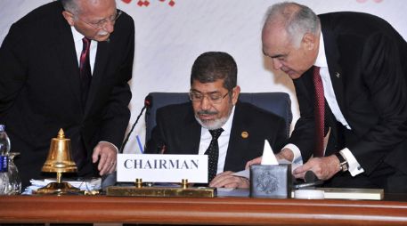 Mohamed Mursi (c) conversando con el secretario general de la Organización de la Cooperación Islámica (OCI), Ekmeleddin ihsanoglu (i). EFE /